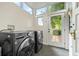 Bright laundry room with front-load washer and dryer set and direct backyard access at 3055 N York St, Denver, CO 80205