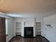 Living room with built-in shelving, fireplace, and dark hardwood floors at 84 S Carlton St, Castle Rock, CO 80104