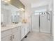 Bright bathroom with double sinks, modern fixtures, and an enclosed glass shower at 1030 W Hopkins Dr, Elizabeth, CO 80107