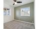 Bright bedroom featuring a gray carpet, two windows, and an olive accent wall at 1030 W Hopkins Dr, Elizabeth, CO 80107