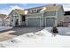 Lovely exterior view of a home featuring a three-car garage, covered porch, and well-maintained landscaping in winter at 1030 W Hopkins Dr, Elizabeth, CO 80107