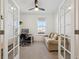 Comfortable home office featuring glass French doors, a ceiling fan, and a cozy couch by the window at 1030 W Hopkins Dr, Elizabeth, CO 80107