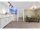 Open-concept kitchen and dining area features white cabinets, bar shelving, and modern lighting at 1030 W Hopkins Dr, Elizabeth, CO 80107