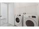 Bright laundry room features a modern washer and dryer and a practical wire rack for storage at 1030 W Hopkins Dr, Elizabeth, CO 80107