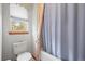 Bathroom featuring a toilet, bathtub with shower curtain, and window at 5723 S Everett Way, Littleton, CO 80123