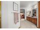 Bright bathroom with wood cabinets, double sinks, and arched doorway to bedroom at 5723 S Everett Way, Littleton, CO 80123
