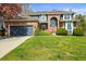 Beautiful two-story home featuring a lush green lawn, brick accents, and a charming arched entryway at 5723 S Everett Way, Littleton, CO 80123