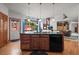 Kitchen island with granite countertop, sink, dishwasher, and seating in a sunny and bright kitchen at 5723 S Everett Way, Littleton, CO 80123