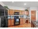 Bright kitchen featuring warm wood cabinetry, black appliances, and lots of counter space at 5723 S Everett Way, Littleton, CO 80123