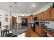Traditional eat-in kitchen with wooden cabinets, granite countertops, stainless steel appliances, and hardwood floors at 5723 S Everett Way, Littleton, CO 80123