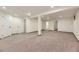 Spacious basement area with neutral carpet, white trim, and multiple access doors for flexible use at 649 Nucla Way, Aurora, CO 80011