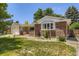 View of a brick home with a well-kept lawn and a covered front porch at 649 Nucla Way, Aurora, CO 80011