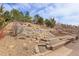 Beautiful backyard featuring tiered landscaping with retaining walls, gravel and wooden fence at 2342 Bellavista St, Castle Rock, CO 80109