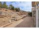 Landscaped backyard with stone retaining walls, a tiered design, mature trees and ground cover at 2342 Bellavista St, Castle Rock, CO 80109