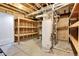 Unfinished basement with exposed beams, shelving, concrete floor, and a hot water heater at 2342 Bellavista St, Castle Rock, CO 80109