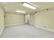 Large open basement area with light-colored epoxy flooring, white walls, and fluorescent ceiling lighting at 2342 Bellavista St, Castle Rock, CO 80109