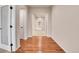 Bright hallway featuring hardwood floors leading to a room with neutral carpet and arched doorways at 2342 Bellavista St, Castle Rock, CO 80109