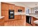 Modern kitchen with wooden cabinetry, a built-in oven, and a sleek cooktop at 2342 Bellavista St, Castle Rock, CO 80109