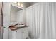 Charming bathroom features a classic vanity with a wood countertop and shower with a white curtain at 5675 S Crocker St, Littleton, CO 80120