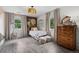 Bright bedroom with a light color palette, light wood floors, a white metal bed frame and unique light fixture at 5675 S Crocker St, Littleton, CO 80120