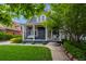 Inviting blue home featuring a cozy porch swing, lush green lawn, and mature shade tree for relaxed outdoor enjoyment at 5675 S Crocker St, Littleton, CO 80120