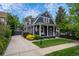 Charming blue two-story home with a manicured lawn, inviting porch swing, and detached garage with concrete driveway at 5675 S Crocker St, Littleton, CO 80120