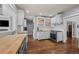 Bright kitchen boasts white cabinets, stainless steel appliances, wood countertops, and hardwood floors at 5675 S Crocker St, Littleton, CO 80120