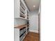 Butler's pantry features white cabinetry, wood counters, open shelving, and hardwood floors at 5675 S Crocker St, Littleton, CO 80120