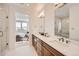 Bathroom with marble counters, wood cabinets, double sinks, and a glass-enclosed shower at 10863 E Hinsdale Cir, Centennial, CO 80112