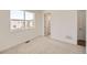 Neutral carpeted bedroom features a large window and direct access to the hallway at 10863 E Hinsdale Cir, Centennial, CO 80112