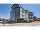 Contemporary home with a dark gray and white facade, showcasing modern design and attached garages at 10863 E Hinsdale Cir, Centennial, CO 80112