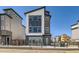 Modern three-story home with a sleek design, large windows, and a well-maintained front yard at 10863 E Hinsdale Cir, Centennial, CO 80112