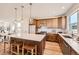 Open kitchen with a large island, wooden cabinetry, stainless steel appliances, and modern pendant lighting at 10863 E Hinsdale Cir, Centennial, CO 80112