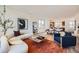 Open-concept living area featuring hardwood floors, modern furniture, and seamless flow to dining and kitchen at 10863 E Hinsdale Cir, Centennial, CO 80112