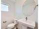 Bright powder room features a pedestal sink, oval mirror, and clean, modern lines at 10863 E Hinsdale Cir, Centennial, CO 80112