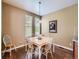Well-lit dining room featuring hardwood floors, modern lighting fixture, and a view to the backyard at 11074 Grayledge Cir, Highlands Ranch, CO 80130