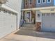 Inviting front entrance with stone accents, two garages and a cozy rocking chair at 11074 Grayledge Cir, Highlands Ranch, CO 80130