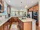 Open kitchen features wood cabinets, granite countertops, and stainless steel appliances with view to living room at 11074 Grayledge Cir, Highlands Ranch, CO 80130