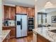Kitchen showcasing stainless steel refrigerator and oven and wood cabinets with breakfast nook nearby at 11074 Grayledge Cir, Highlands Ranch, CO 80130