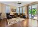 Spacious living room with hardwood floors, stylish furniture, and natural light from sliding glass door at 11074 Grayledge Cir, Highlands Ranch, CO 80130