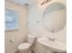 Clean bathroom with a round mirror and toilet at 5833 N Biscay St, Denver, CO 80249