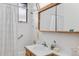 Bright, clean bathroom features a bathtub/shower, vanity, mirror, and functional storage at 1420 E Bates Ave, Englewood, CO 80113