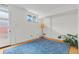 Bright bedroom features a blue rug, white walls, and a sunny window at 1420 E Bates Ave, Englewood, CO 80113