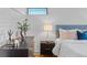 Bedroom features updated decor, a stylish nightstand, and a refinished brick wall at 1420 E Bates Ave, Englewood, CO 80113