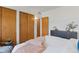 Bedroom view featuring closet doors, a dresser, an adjacent bathroom door and an updated brick wall at 1420 E Bates Ave, Englewood, CO 80113