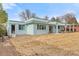Back exterior view of home featuring a wooden deck, covered patio, and spacious yard at 1420 E Bates Ave, Englewood, CO 80113