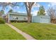View of single story home and green lawn with mature tree in the front yard on a sunny day at 1420 E Bates Ave, Englewood, CO 80113