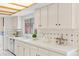 Well-lit kitchen featuring white cabinets, ample counter space, and tiled backsplash, creating a clean design at 1420 E Bates Ave, Englewood, CO 80113
