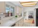 Bright kitchen boasts white cabinets, ample counter space, and a view to the living room, ideal for entertaining at 1420 E Bates Ave, Englewood, CO 80113