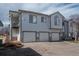 Charming three-car garage exterior with a light blue facade and well-manicured landscaping at 3242 E 103Rd Dr # 602, Thornton, CO 80229